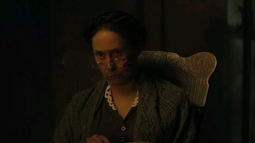Monster: The Ed Gein Story Review — Ryan Murphy and Charlie Hunnam Mistake Provocation for Substance 19 a woman knits while listening