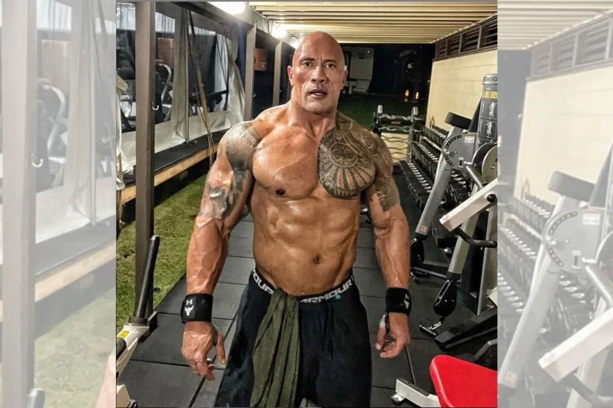 A shirtless Dwayne Johnson poses for the camera.