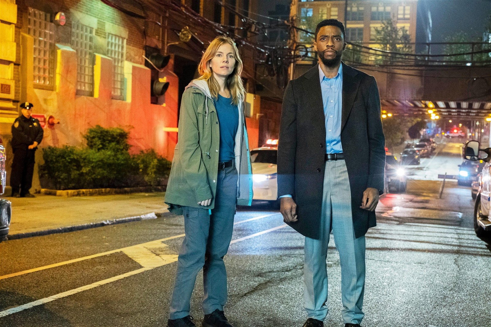 Sienna Miller and Chadwick Boseman in 21 Bridges (2019).
