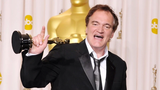 Quentin Tarantino holding an Oscar.