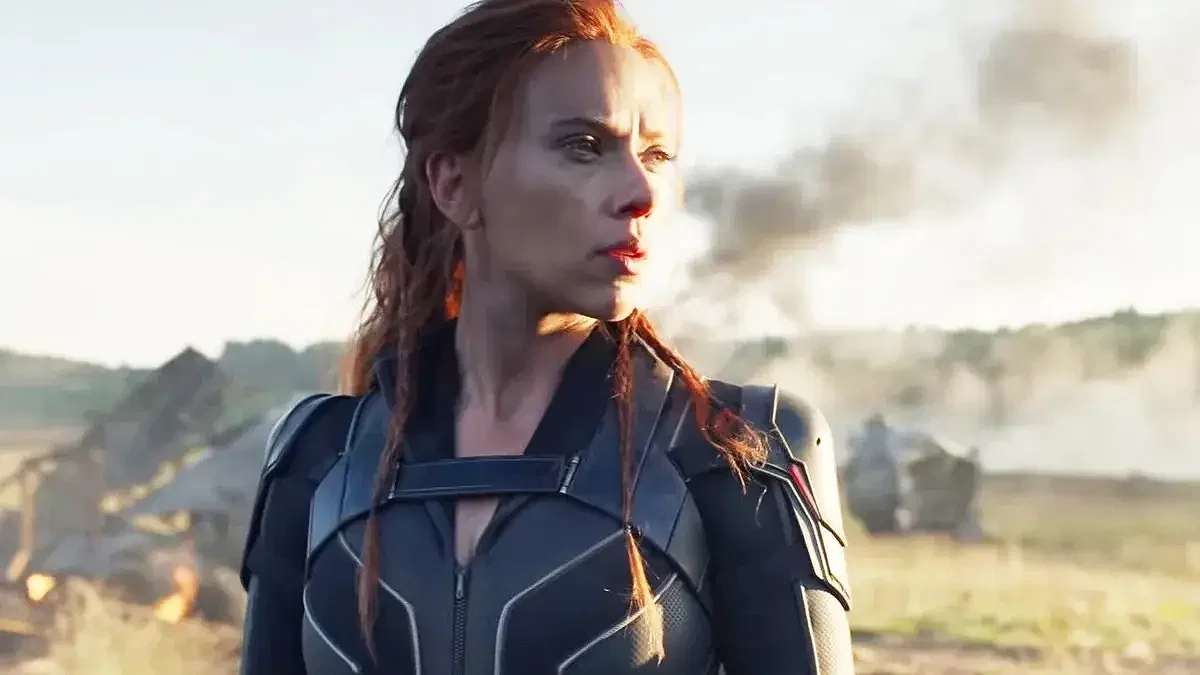 Scarlett Johansson looking to her left with destruction in the background in Black Widow