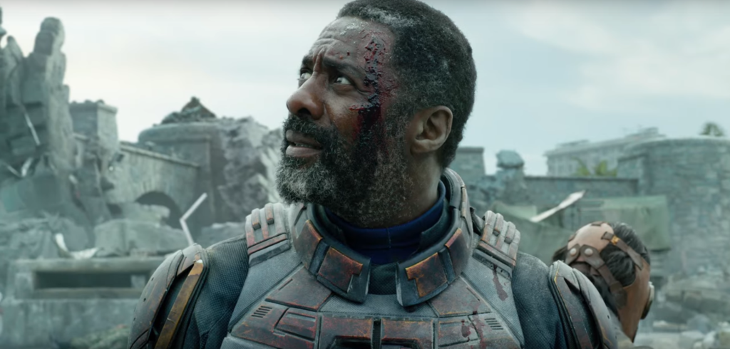 Idris Elba as Bloodsport looking at a kaiju in The Suicide Squad