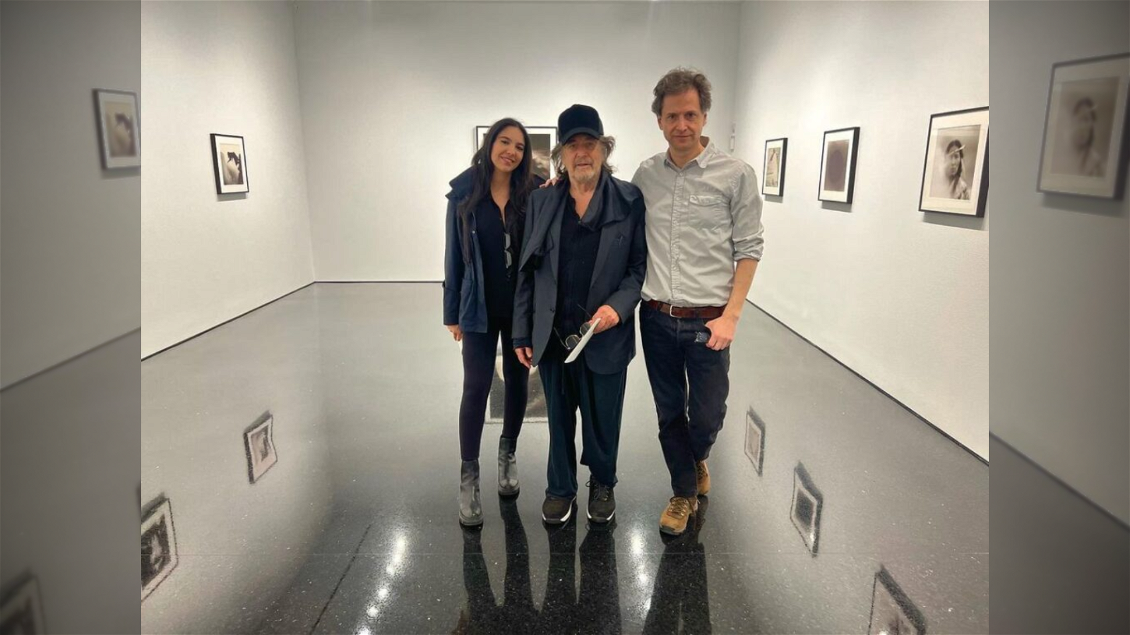 Al Pacino poses with his girlfriend Noor Alfallah and another man in an art gallery.