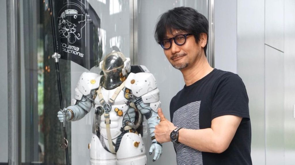 Hideo Kojima posing next to a space suit