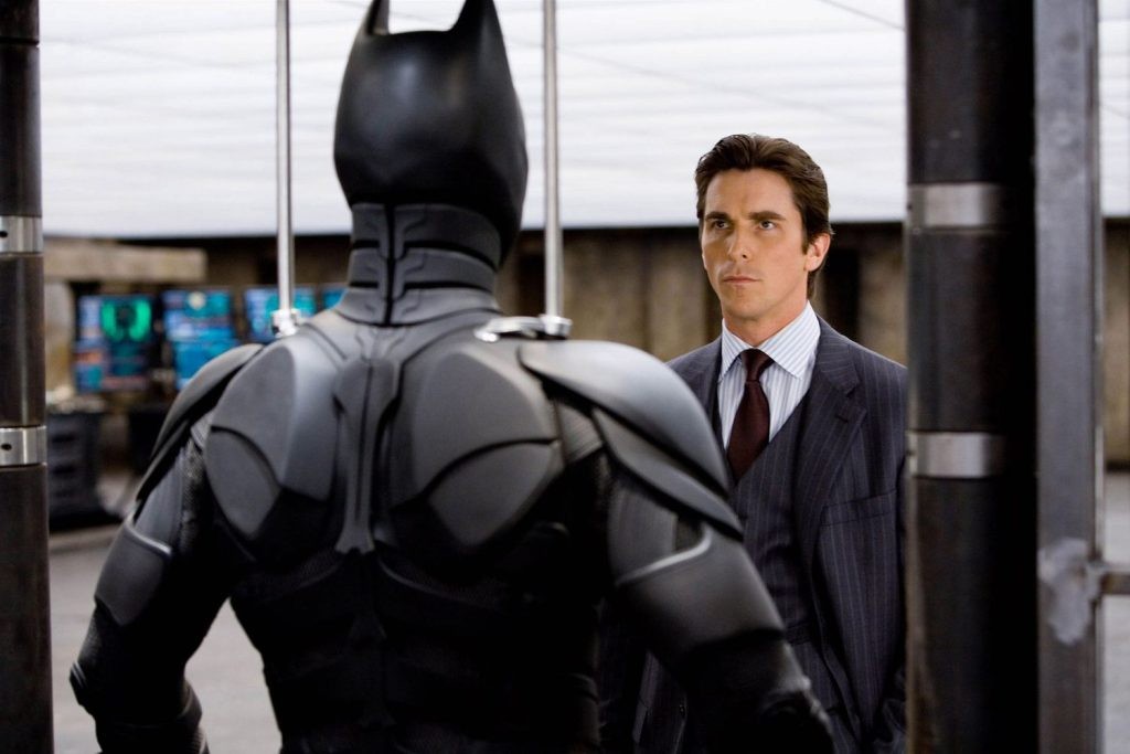 Christian Bale's Batman near his Batsuit
