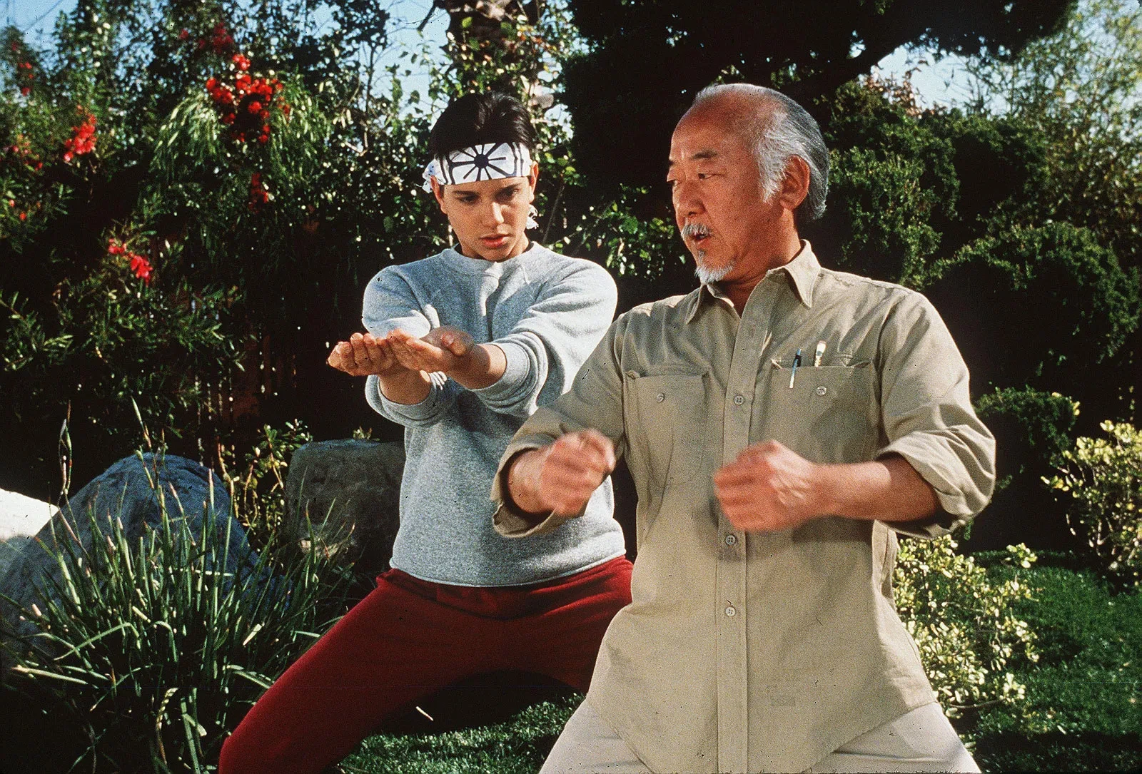 Pat Morita and Ralph Macchio in a still from The Karate Kid series
