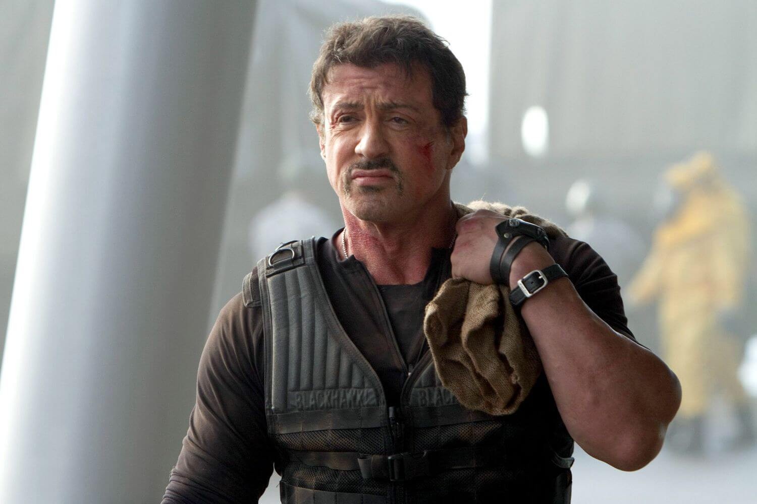 Sylvester Stallone looking annoyed after a job in The Expendables