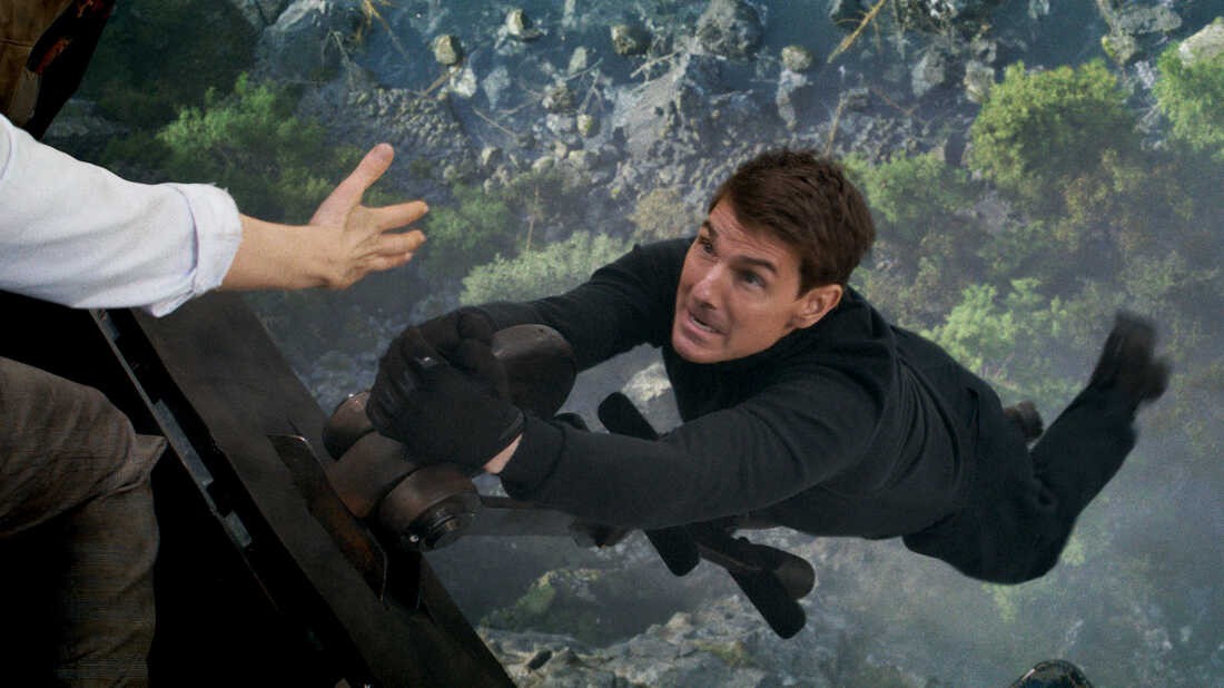 Tom Cruise hanging on for deal life in a scene from one of the Mission: Impossible movies