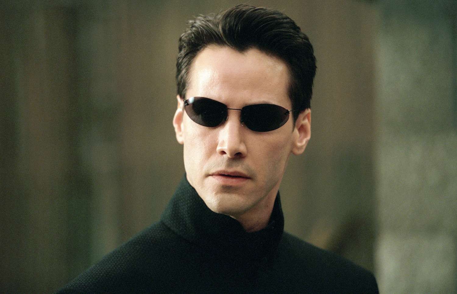 Keanu Reeves with his signature sunglasses staring on in The Matrix