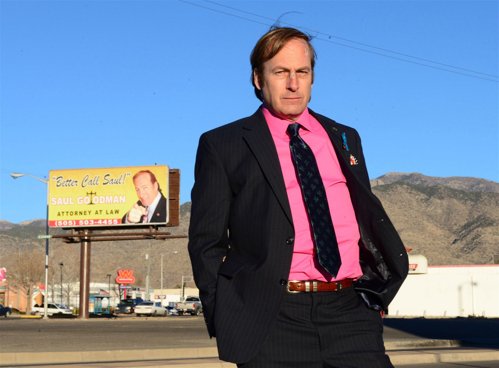 Saul Goodman while waiting outside his office in front of an advertisement sign board