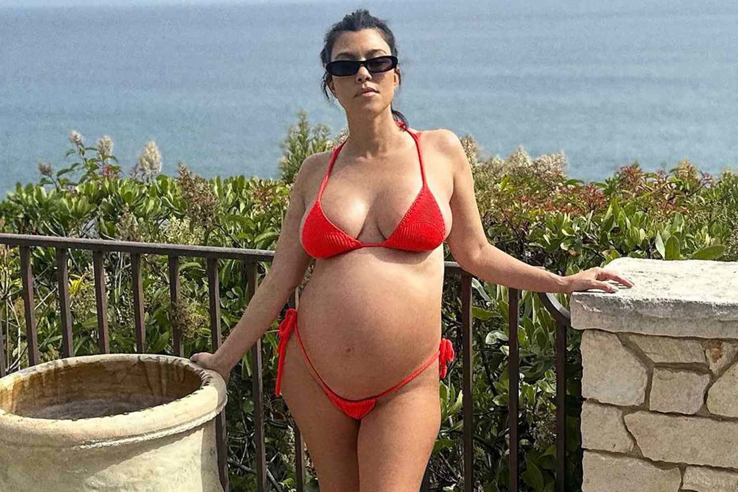 Kourtney Kardashian wearing a red bikini while being pregnant 