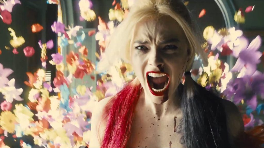 Harley Quinn shouting while flowers burst behind her in The Suicide Squad