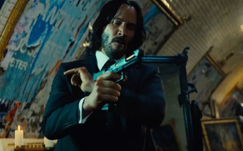 Keanu Reeves holding a gun as John Wick 