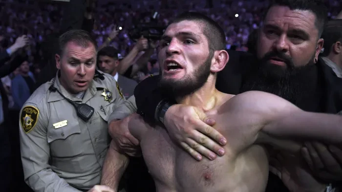 Khabib Nurmagomedov being restrained and escorted out in UFC 229