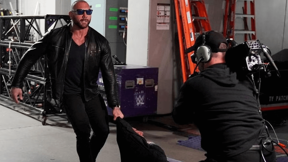 Dave Bautista dragging Ric Flair through the floor to seek Triple H's attention