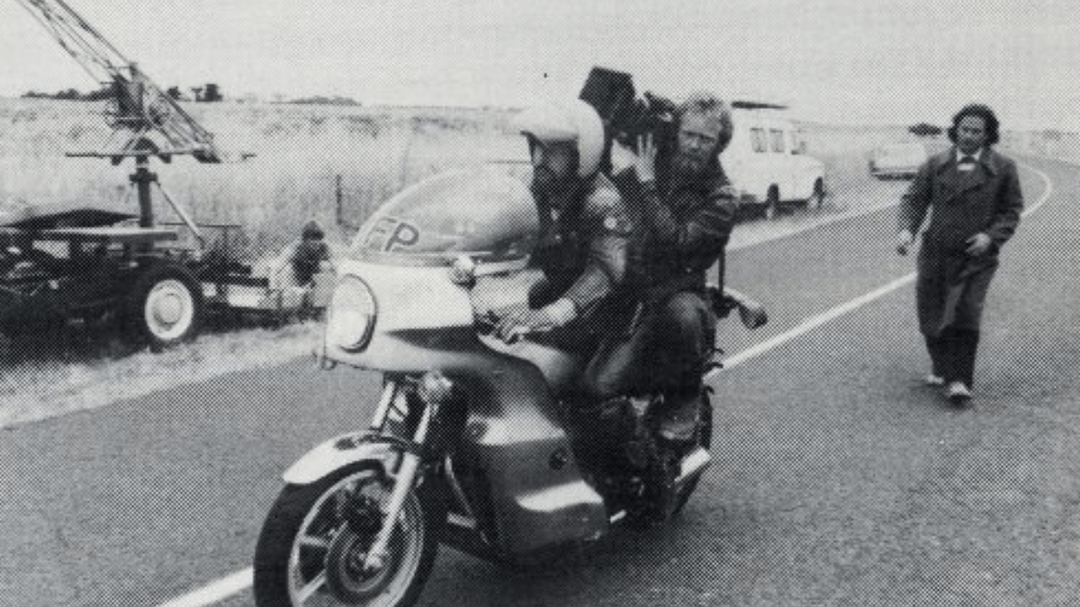 BTS footage showing cinematographer David Eggby with a camera on a motorbike