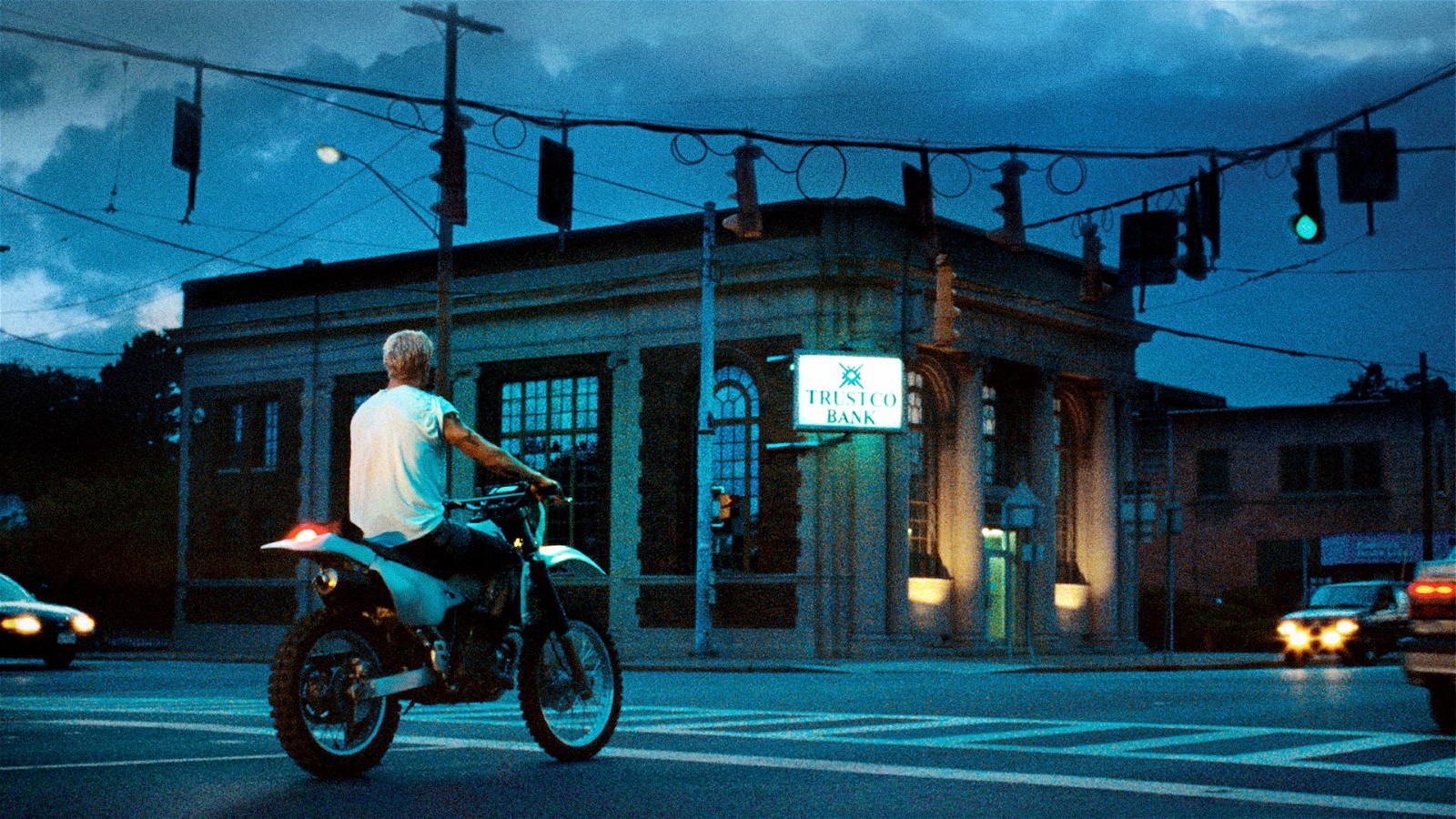 Ryan Gosling waits outside a bank on his bike in The Place Beyond The Pines