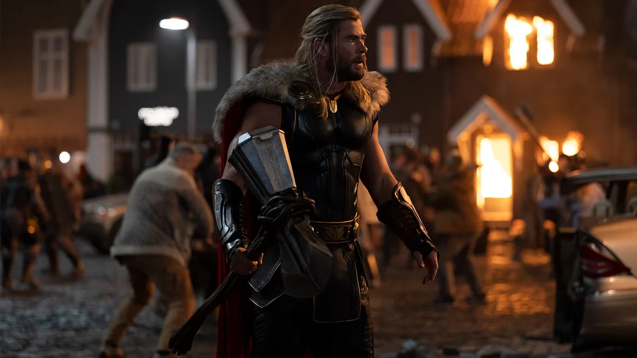 Chris Hemsworth with Stormbreaker amidst a battle with Gorr in Thor: Love and Thunder