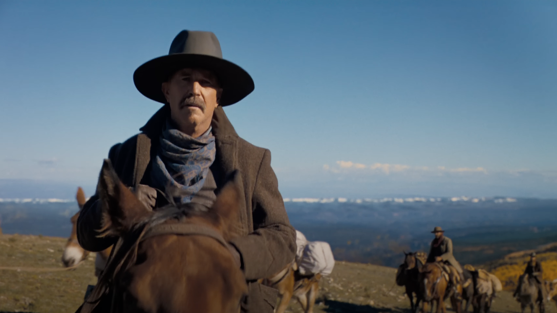 Kevin Costner rides atop a horse in the Western landscapes of America in Horizon: An American Saga