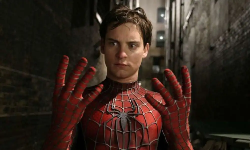 Tobey Maguire as Spider-Man looking at his hands in shock.