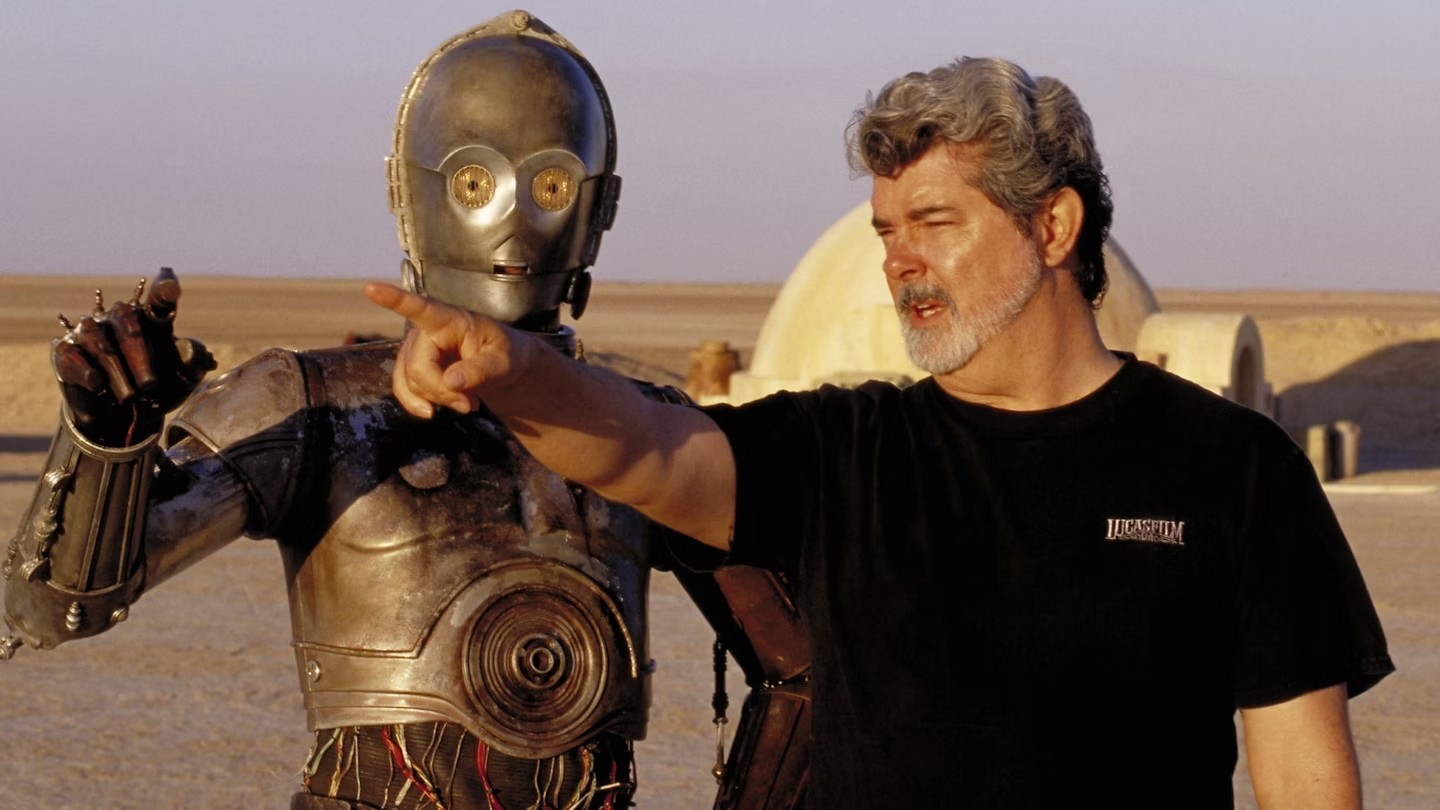 George Lucas on the planet of Tatooine along with C3PO on the sets of Star Wars: A New Hope | Credits: LucasFilm