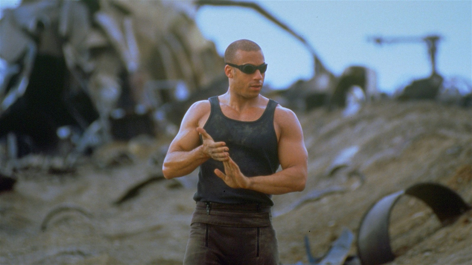 Vin Diesel as Riddick walks along an abandoned land in a still from Pitch Black