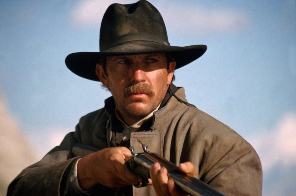 Kevin Costner in Horizon: An American Saga holding a gun