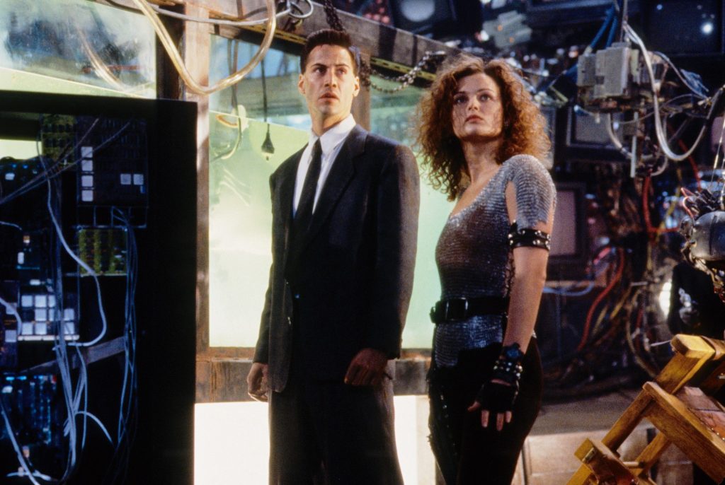 Keanu Reeves and Dina Meyer standing and looking with wonder in Johnny Mnemonic (1995)
