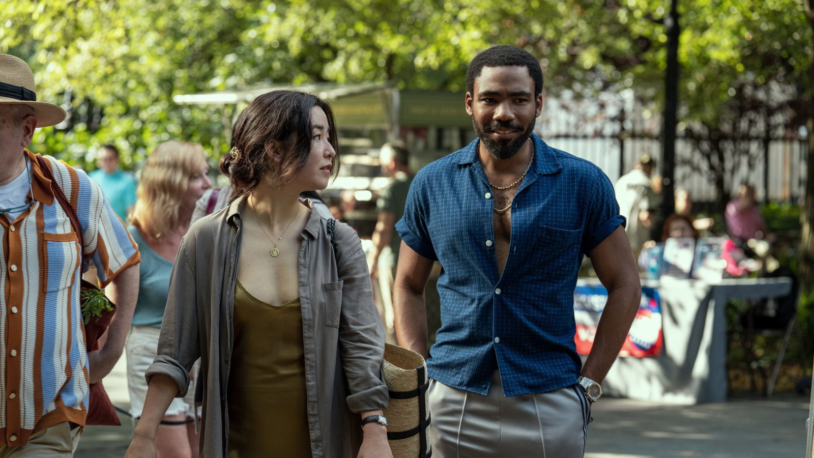 Donald Glover and Maya Erskine walk along a crowded street in Mr. & Mrs. Smith