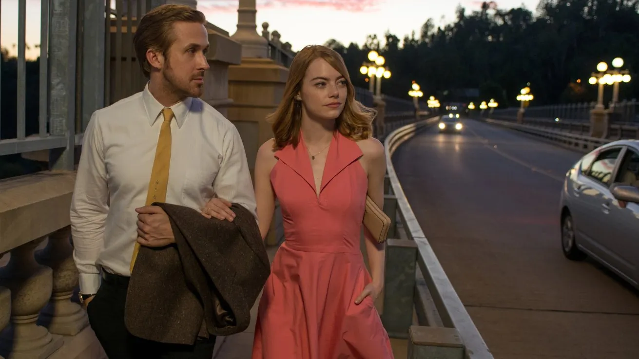 Ryan Gosling and Emma Stone walk along LA in a still from La La Land