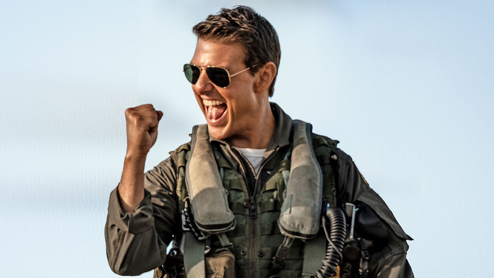 Tom Cruise smiling and cheering in a still from Top Gun: Maverick