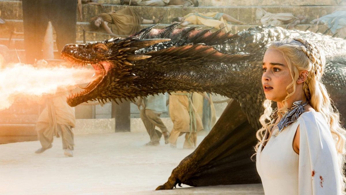 Emilia Clarke alongside her dragon, Rhaegal, breathing fire, in Game of Thrones