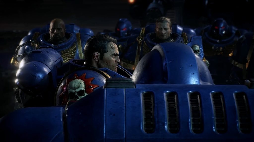 A screenshot from a Warhammer 40K: Space Marine 2 trailer featuring a squad of Ultramarines standing in attention while Lieutenant Titus walks past.