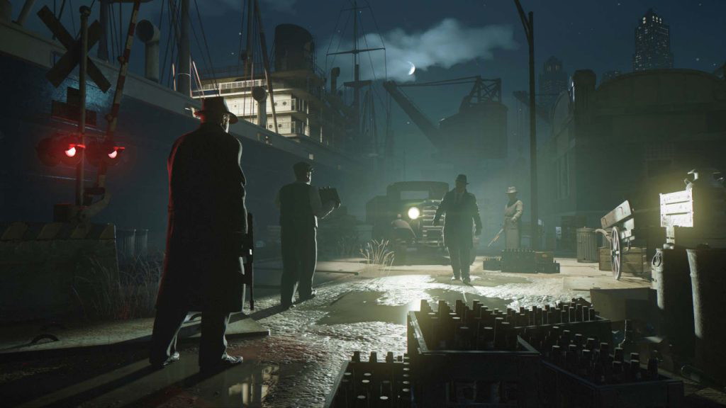 Mafia: Definitive Edition screenshot showing four gangsters at a dock at night