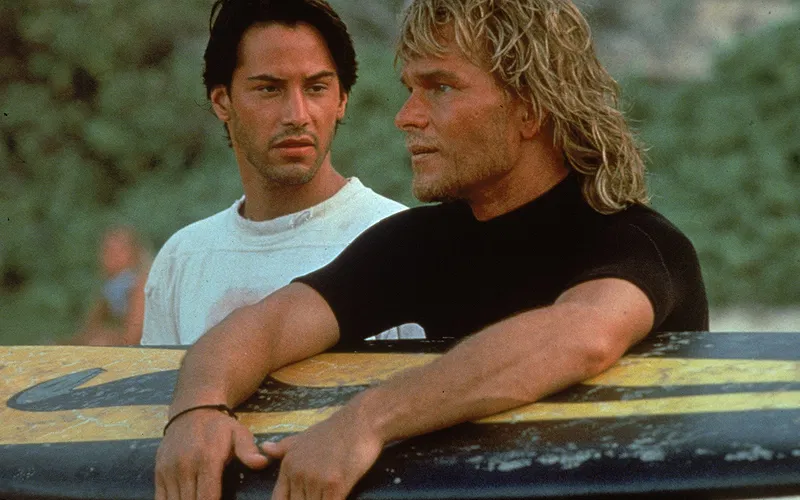 Patrick Swayze and Keanu Reeves standing together in Point Break