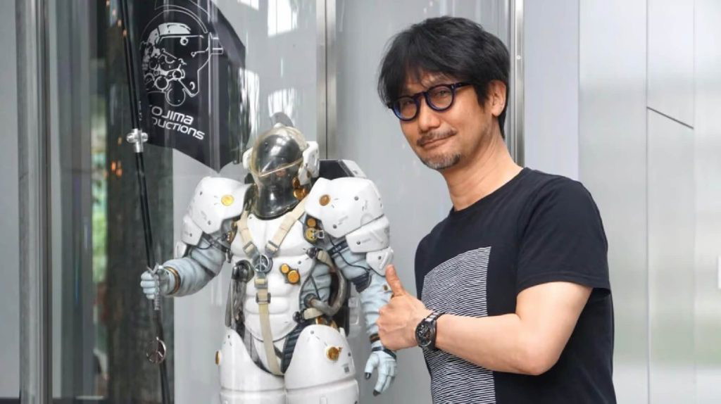 Hideo Kojima posing with a Ludens statue.