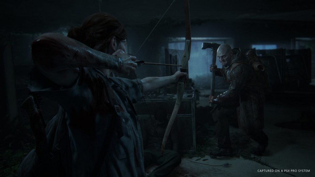 Ellie from “The Last of Us Part 2” aims her bow at a brute with a sledgehammer.