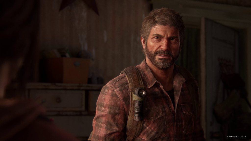 Joel from The Last of Us looking intensely at someone off screen during a conversation.