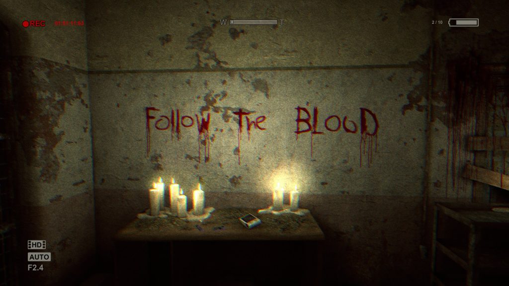 An image from Outlast, showing "Follow the blood" written in blood. 