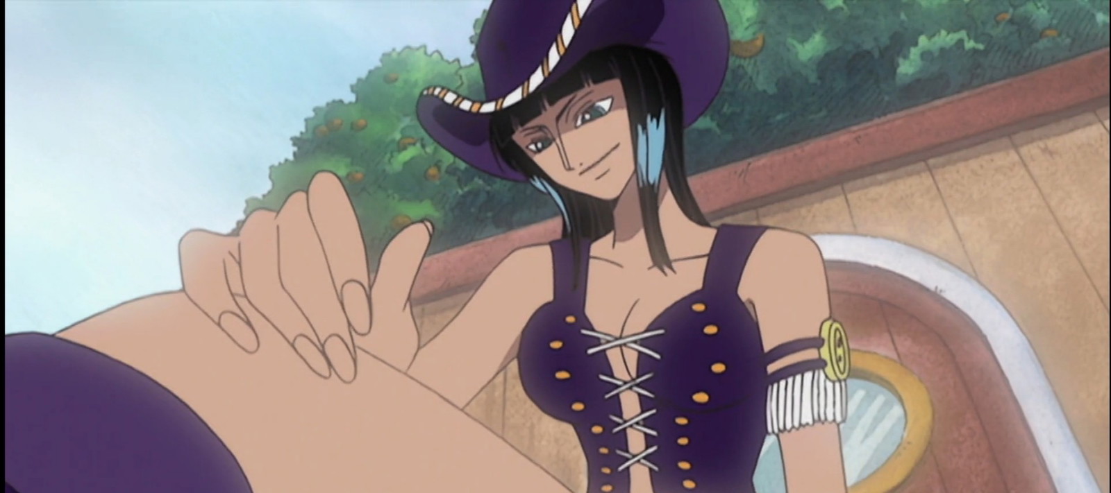 Nico Robin is sitting on a ship with one of her hands on her knees in Netflix’s One Piece