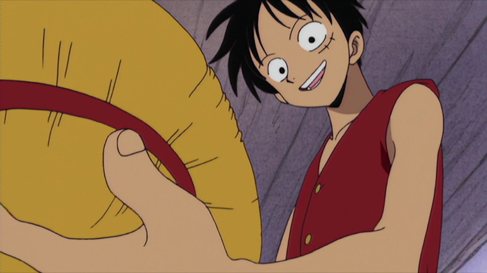 Luffy is looking downwards at the straw hat in his hand in One Piece