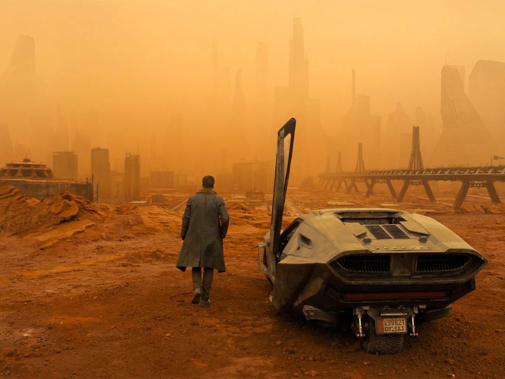 Ryan Gosling exits a futuristic car in Blade Runner 2049.