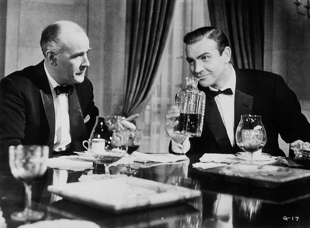 Sean Connery (R) and Richard Vernon (L) make a drink in Goldfinger (1964) | Credits: United Artists