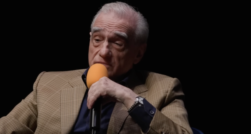 Martin Scorsese holding a mic and talking. 