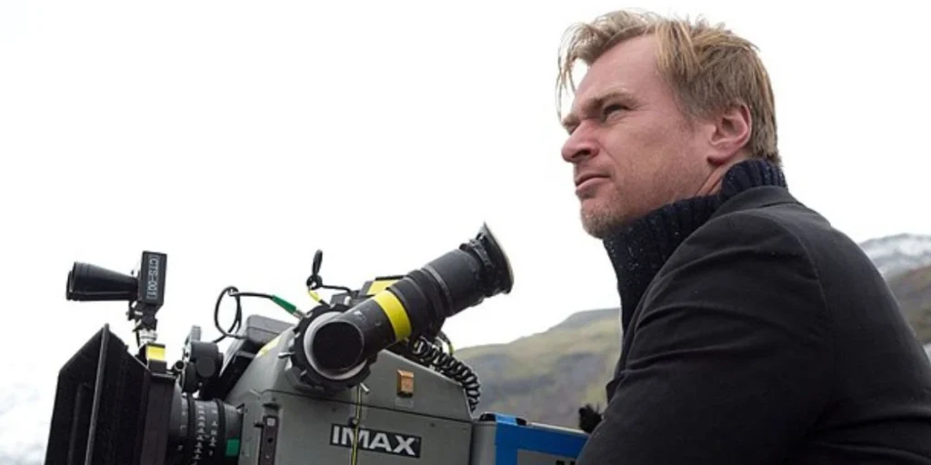 Christopher Nolan directing a film standing near an IMAX camera