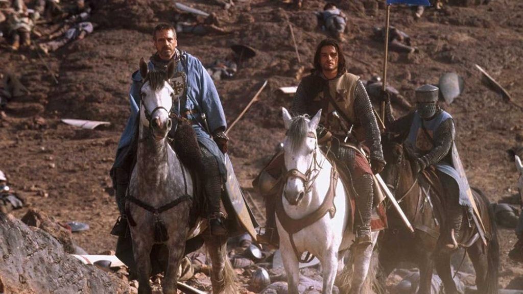 Ridley Scott directs Kingdom of Heaven. (L to R) Jeremy Iron wears all blue while riding a dark grey horse. Orlando bloom wears his armor while riding a white horse. 