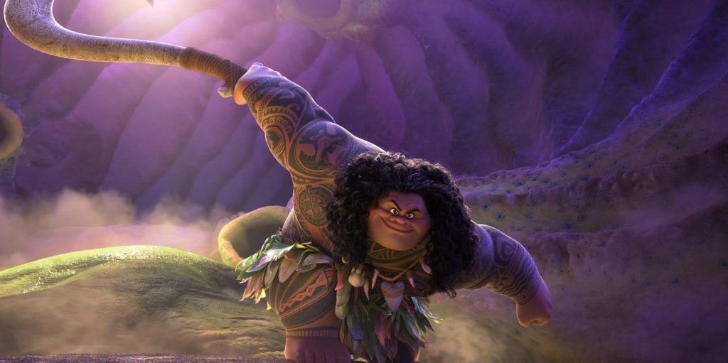 The Rock’s Maui is sporting his iconic long, dark hair, intricate tattoos, and massive muscular build.