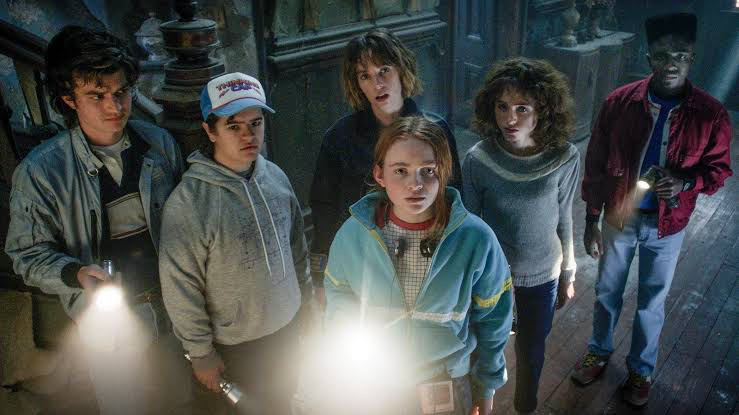 Sadie Sink in a scene from Stranger Things with Gaten Matarazzo, Joe Keery, Natalia Dyer and others