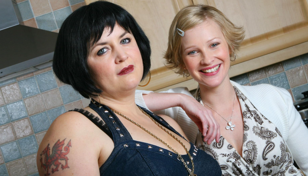 Ruth Jones and Joanna Page stand together in a kitchen scene from Gavin & Stacey. 