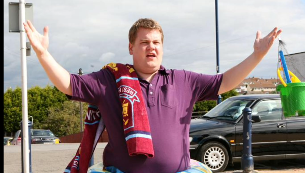 James Corden in Gavin & Stacey, holding a towel while standing in a playful, comedic pose. 